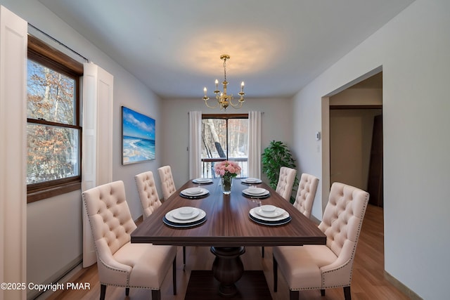 dining space featuring a chandelier and light hardwood / wood-style flooring