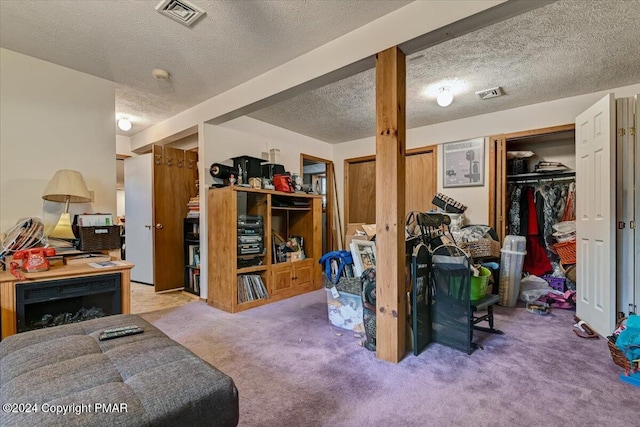 below grade area with a textured ceiling, carpet, and visible vents