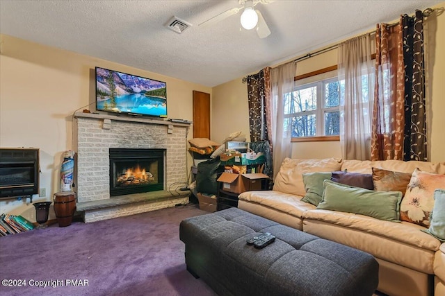 living area with visible vents, a ceiling fan, a brick fireplace, carpet flooring, and a textured ceiling