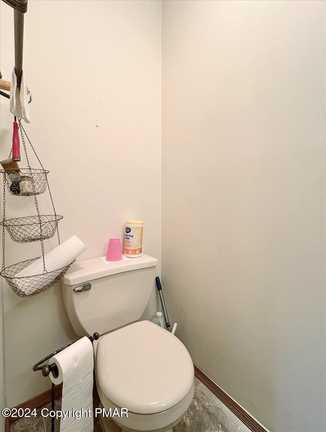 bathroom with toilet and baseboards