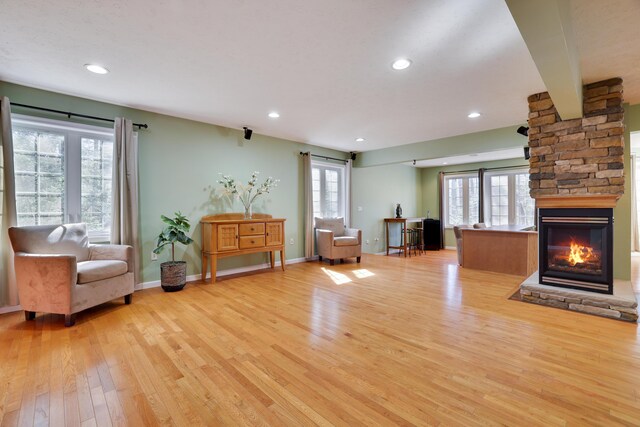 unfurnished room featuring recessed lighting, a fireplace, light wood-type flooring, and baseboards