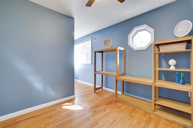 interior space with baseboards, ceiling fan, and wood finished floors