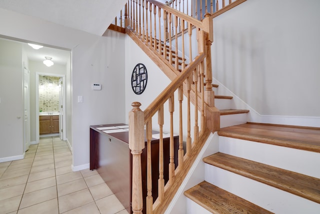 stairway with tile patterned floors and baseboards