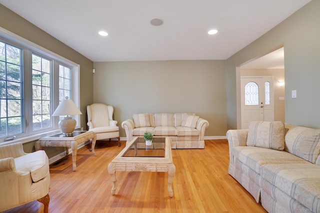 living room with recessed lighting, baseboards, and light wood-style flooring