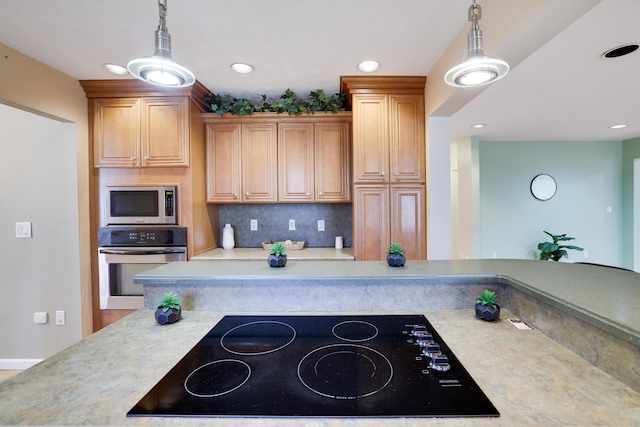 kitchen with stainless steel appliances, tasteful backsplash, pendant lighting, and light countertops
