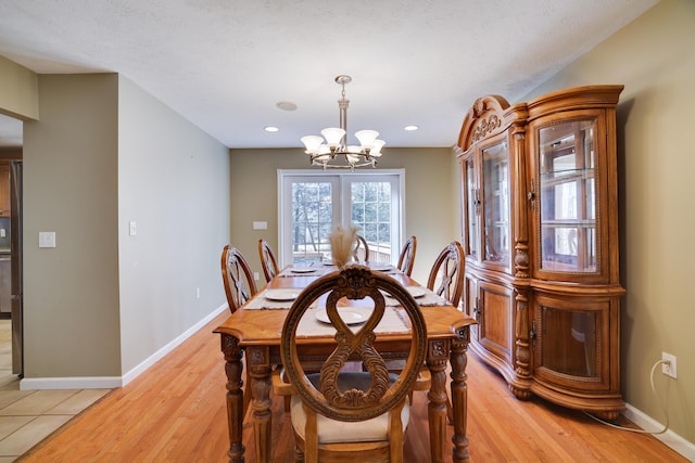 dining area featuring recessed lighting, light wood-style flooring, baseboards, and an inviting chandelier