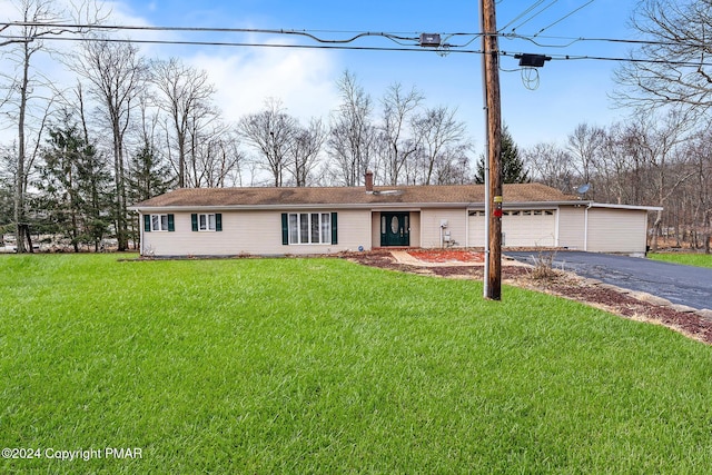 ranch-style home with aphalt driveway, a garage, a chimney, and a front lawn