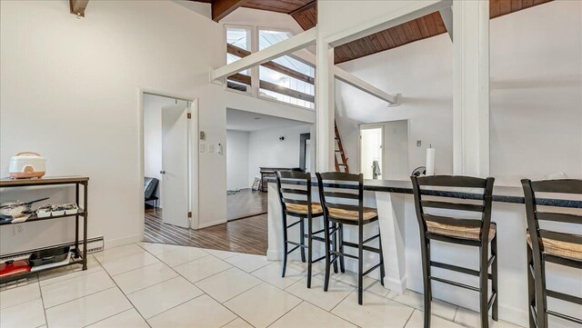 725 Clearview Dr, Long Pond, PA 18334 - kitchen with a breakfast bar area, high vaulted ceiling, beam ceiling, dark countertops, and baseboards