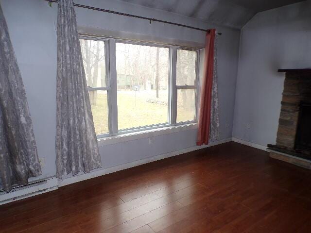 1292 Brentwood Dr, East Stroudsburg, PA 18301 - unfurnished living room featuring lofted ceiling, wood finished floors, a stone fireplace, and baseboards
