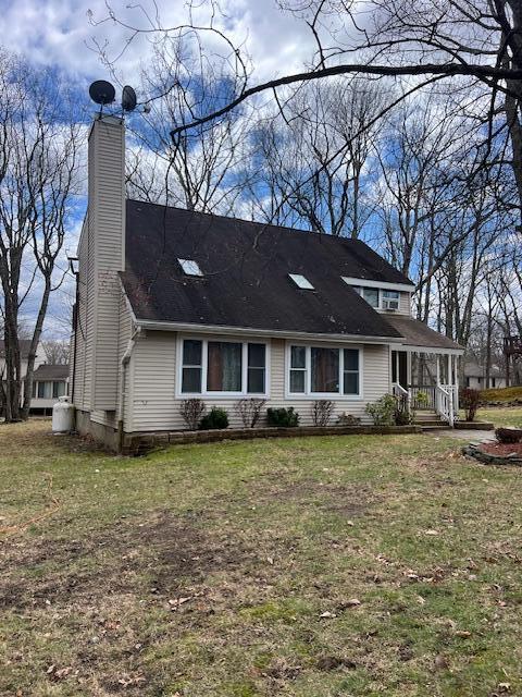 1292 Brentwood Dr, East Stroudsburg, PA 18301 - view of front of house with a front yard, a chimney, and a porch