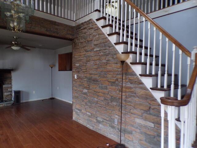 1292 Brentwood Dr, East Stroudsburg, PA 18301 - staircase featuring ceiling fan, baseboards, wood-type flooring, and a towering ceiling