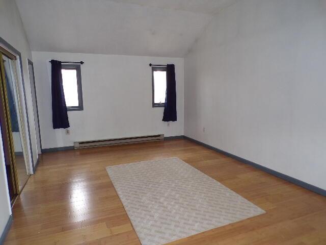 1292 Brentwood Dr, East Stroudsburg, PA 18301 - unfurnished room with vaulted ceiling, baseboard heating, plenty of natural light, light wood-style flooring, and baseboards