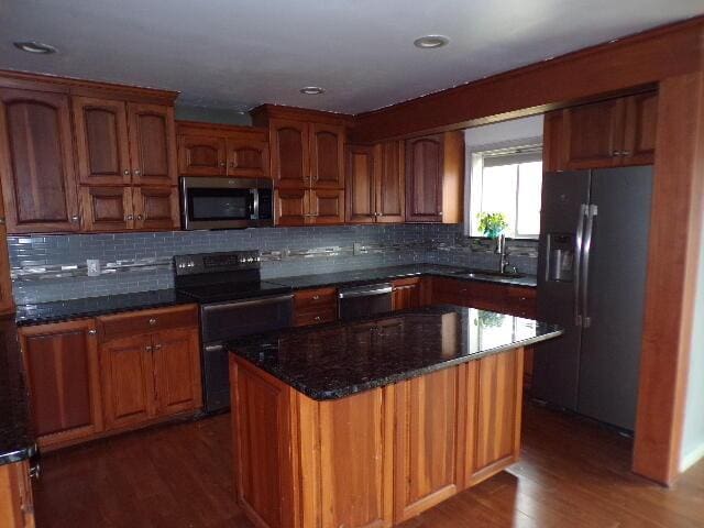 1292 Brentwood Dr, East Stroudsburg, PA 18301 - kitchen with appliances with stainless steel finishes, a sink, dark wood-style floors, dark stone countertops, and decorative backsplash
