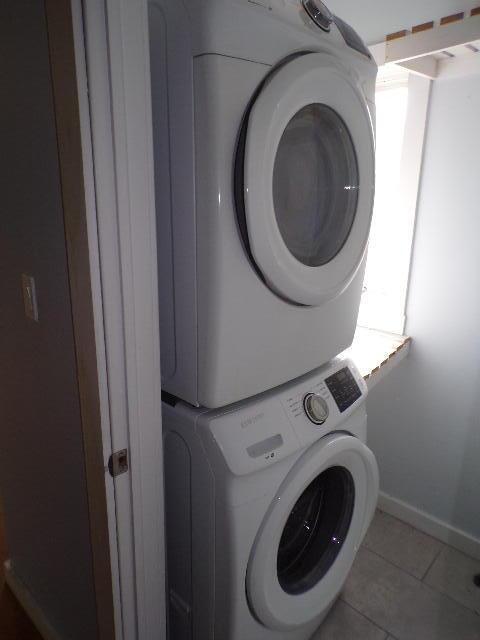 1292 Brentwood Dr, East Stroudsburg, PA 18301 - clothes washing area featuring estacked washer and dryer, light tile patterned flooring, and baseboards