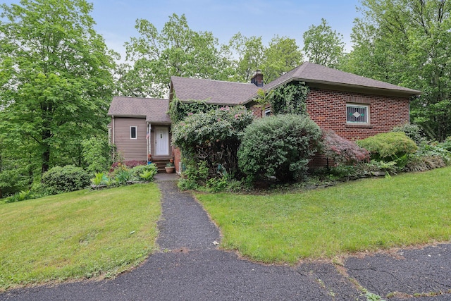 5245 Glenbrook Rd, Stroudsburg, PA 18360 - view of front of property with a chimney, brick siding, a front yard, and roof with shingles