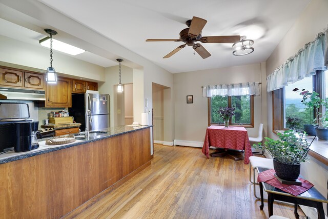 5245 Glenbrook Rd, Stroudsburg, PA 18360 - kitchen featuring freestanding refrigerator, brown cabinets, a sink, light wood-style flooring, and under cabinet range hood