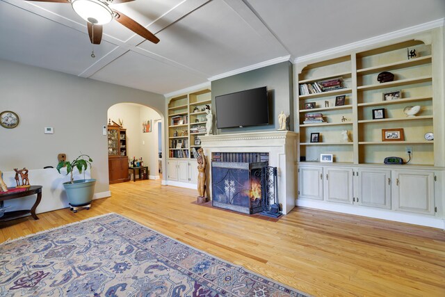 5245 Glenbrook Rd, Stroudsburg, PA 18360 - living area featuring a ceiling fan, arched walkways, light wood finished floors, a warm lit fireplace, and built in features