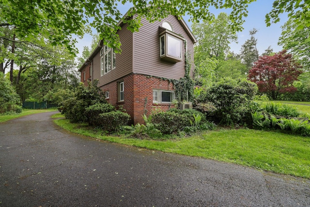 5245 Glenbrook Rd, Stroudsburg, PA 18360 - view of side of home featuring brick siding, central air condition unit, and a yard