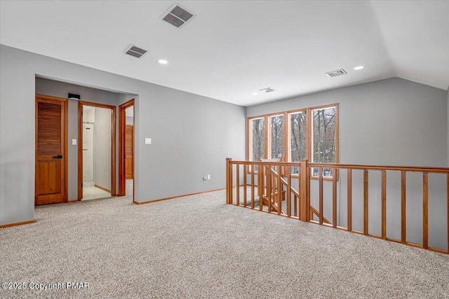 unfurnished room featuring vaulted ceiling and light colored carpet