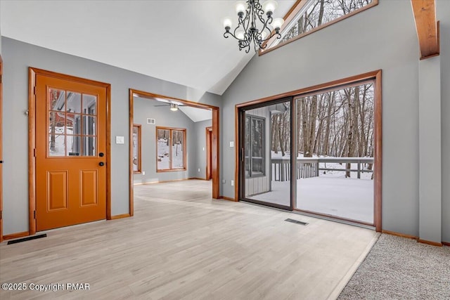 foyer featuring a healthy amount of sunlight, an inviting chandelier, and light wood-type flooring