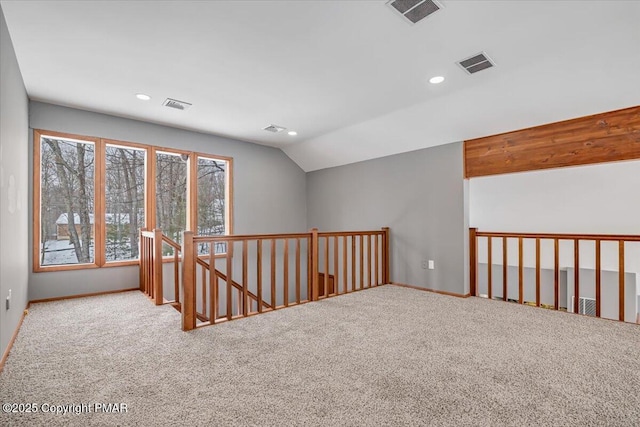 spare room with vaulted ceiling and carpet flooring