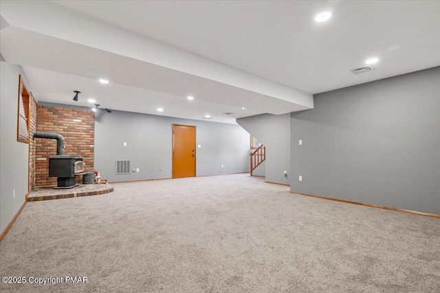 basement with carpet floors and a wood stove