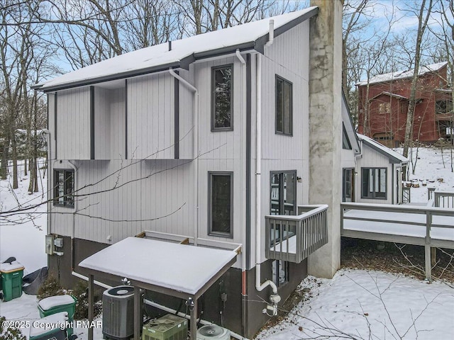 snow covered property featuring cooling unit