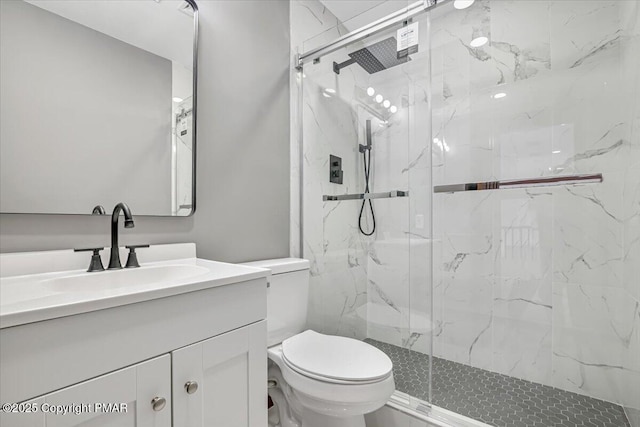 bathroom featuring vanity, toilet, and a shower with shower door