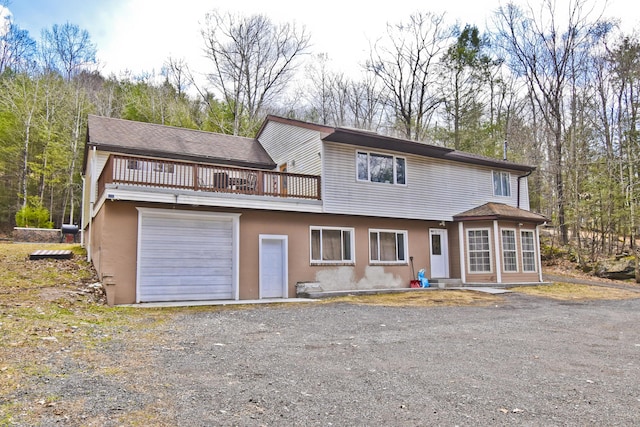 982 Long Ridge Rd, Hawley, PA 18428 - view of front of house with stucco siding, an attached garage, and dirt driveway