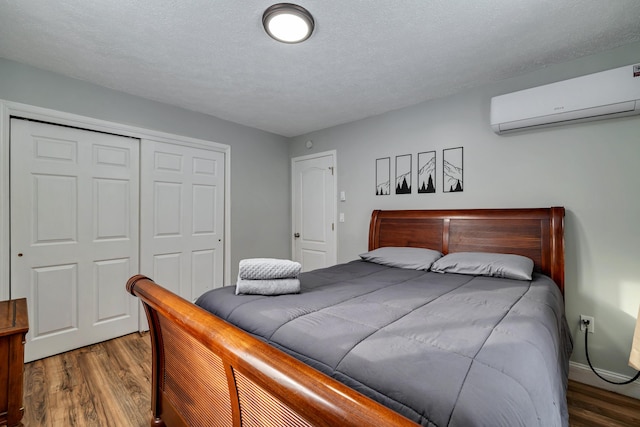 982 Long Ridge Rd, Hawley, PA 18428 - bedroom with an AC wall unit, baseboards, a textured ceiling, a closet, and wood finished floors