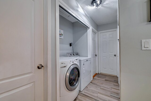 982 Long Ridge Rd, Hawley, PA 18428 - washroom with washing machine and dryer, a textured ceiling, laundry area, and light wood-style floors