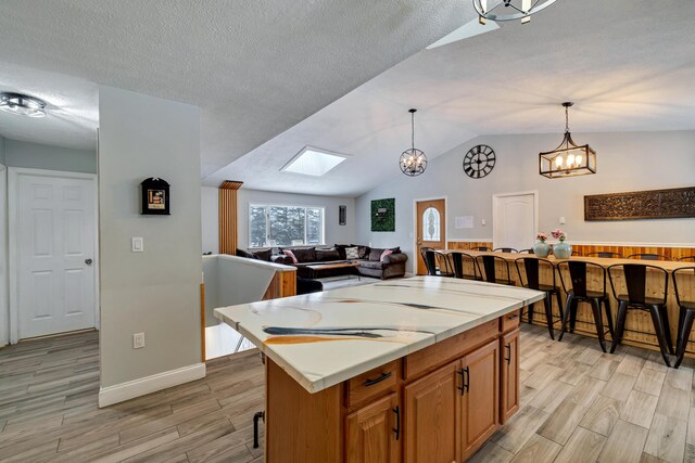 982 Long Ridge Rd, Hawley, PA 18428 - kitchen with vaulted ceiling with skylight, light countertops, a chandelier, open floor plan, and wood finish floors