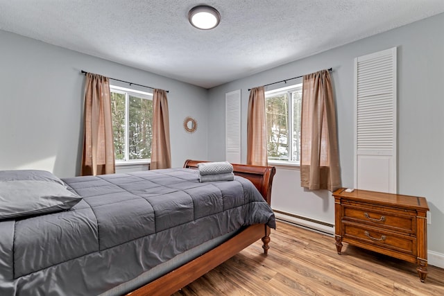 982 Long Ridge Rd, Hawley, PA 18428 - bedroom featuring multiple windows, baseboard heating, wood finished floors, and a textured ceiling