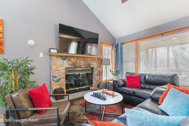 living room with high vaulted ceiling and a stone fireplace