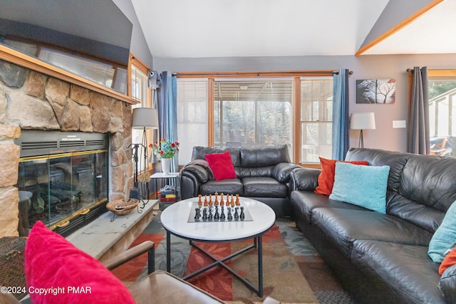 living area featuring lofted ceiling and a fireplace