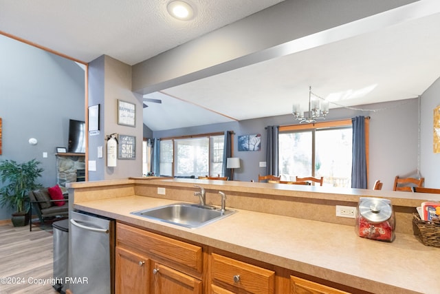 kitchen featuring lofted ceiling with beams, open floor plan, a sink, and a wealth of natural light