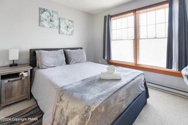 bedroom with baseboard heating and carpet flooring