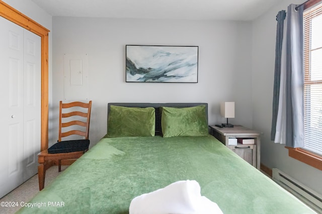 bedroom with a baseboard radiator and a closet