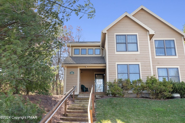 view of front of house with a front lawn and roof with shingles