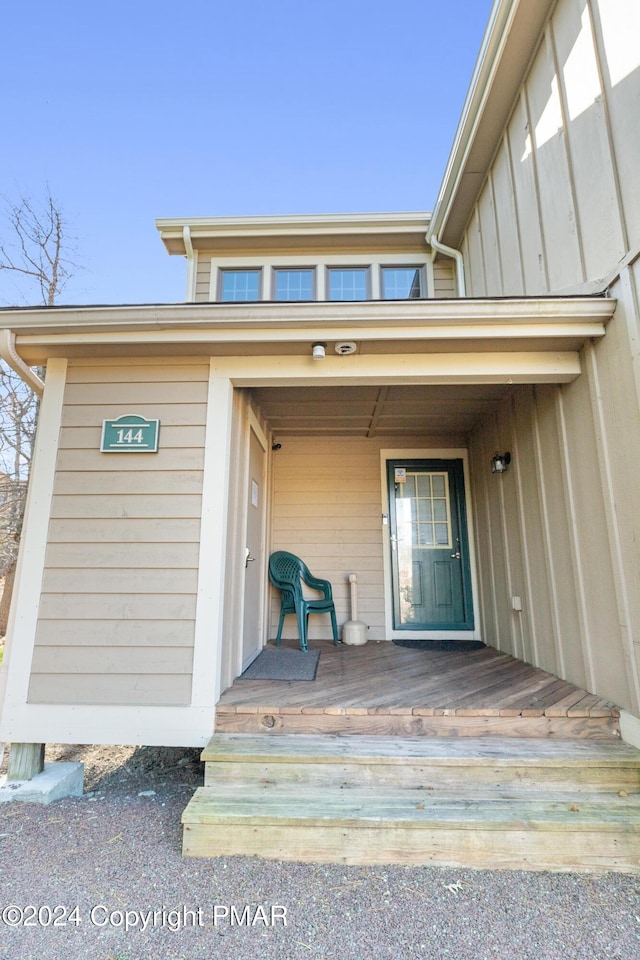 property entrance with board and batten siding and a porch