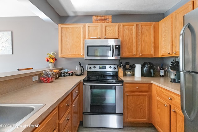 kitchen with a sink, stainless steel appliances, and light countertops