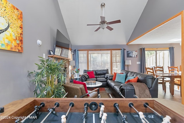 living room featuring ceiling fan and high vaulted ceiling