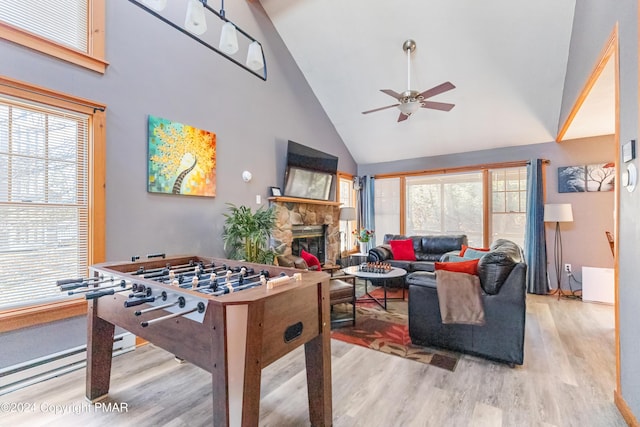 playroom featuring high vaulted ceiling, a fireplace, wood finished floors, and a ceiling fan