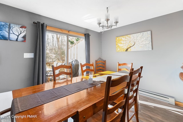 dining room with a baseboard heating unit, a chandelier, and wood finished floors