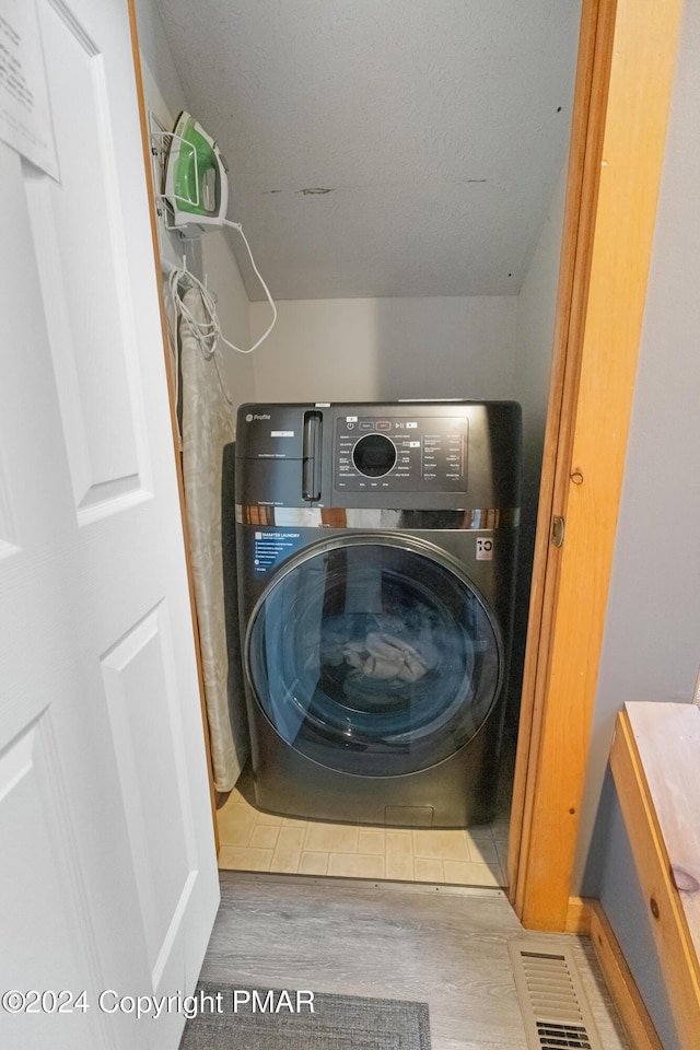 laundry room featuring washer / dryer, laundry area, and wood finished floors