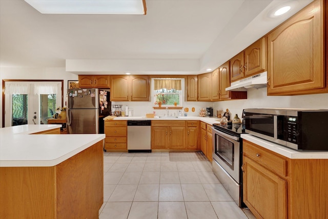 146 Bernadette Dr, Dingmans Ferry, PA 18328 - kitchen featuring stainless steel appliances, a sink, under cabinet range hood, light tile patterned floors, and light countertops