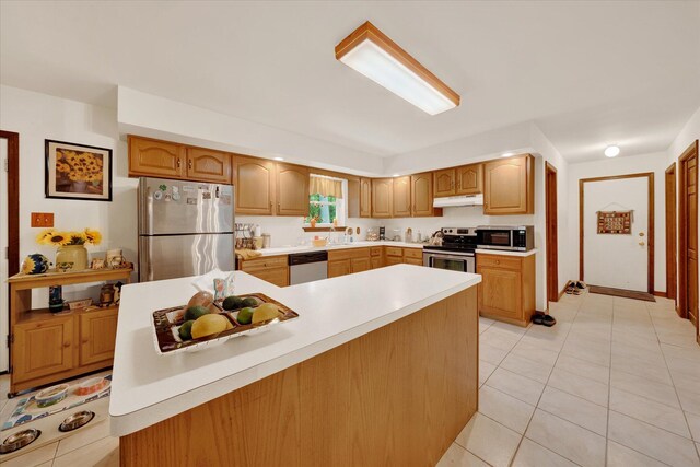 146 Bernadette Dr, Dingmans Ferry, PA 18328 - kitchen with stainless steel appliances, under cabinet range hood, light countertops, a sink, and light tile patterned flooring