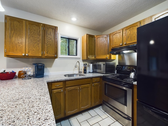 kitchen featuring appliances with stainless steel finishes, brown cabinets, a sink, and under cabinet range hood