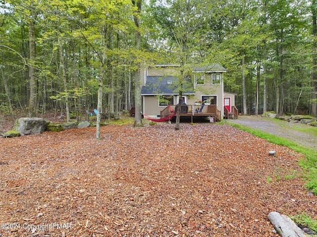 view of front facade featuring a deck, crawl space, and a view of trees