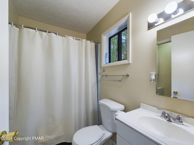 full bathroom featuring a textured ceiling, vanity, and toilet